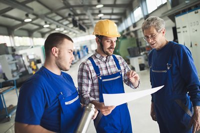 Workers looking at blueprints of control chart