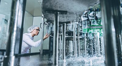 Worker checking on bottling line 