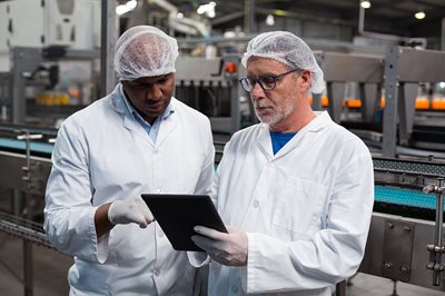 engineers looking at plant floors on a tablet