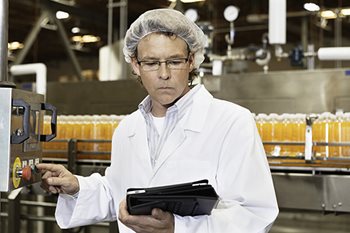 Person in a lab coat looking at data on a tablet
